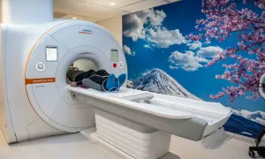 Pacjent leży na łóżku rezonansu magnetycznego. Czy na rezonans trzeba mieć skierowanie? To zależy od placówki i rodzaju badania.