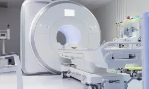 Nowoczesny gabinet diagnostyczny z aparaturą do rezonansu kręgosłupa szyjnego. Obok leżanka i sprzęt medyczny.