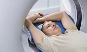 Mężczyzna leży w aparacie rezonansu magnetycznego. Czy przed rezonansem można jeść? Zależy od badania.