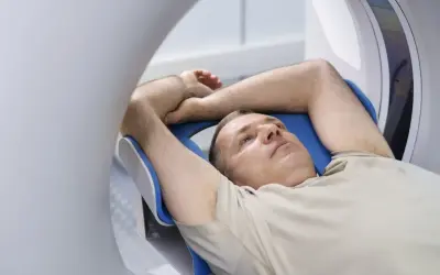 Mężczyzna leży w aparacie rezonansu magnetycznego. Czy przed rezonansem można jeść? Zależy od badania.