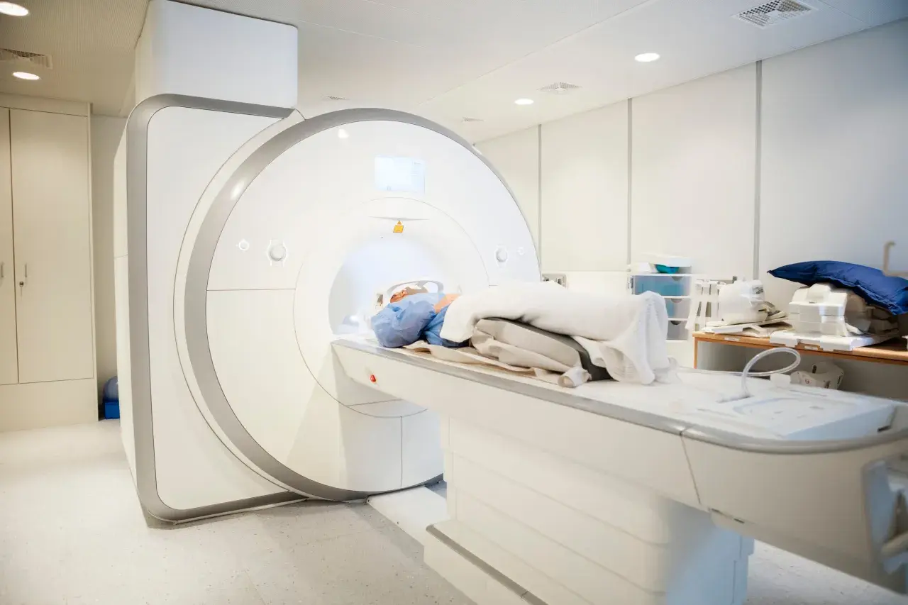 Pacjent leży w aparacie do rezonansu magnetycznego, który wykonuje badanie kręgosłupa w celu diagnozy przepukliny.