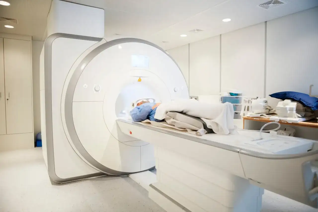 Pacjent leży w aparacie do rezonansu magnetycznego, który wykonuje badanie kręgosłupa w celu diagnozy przepukliny.